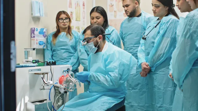 Students gathered around a live crown-preparation demonstration.