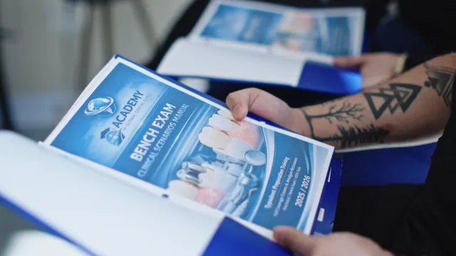 Student reviewing the printed Bench Exam program workbook during orientation.
